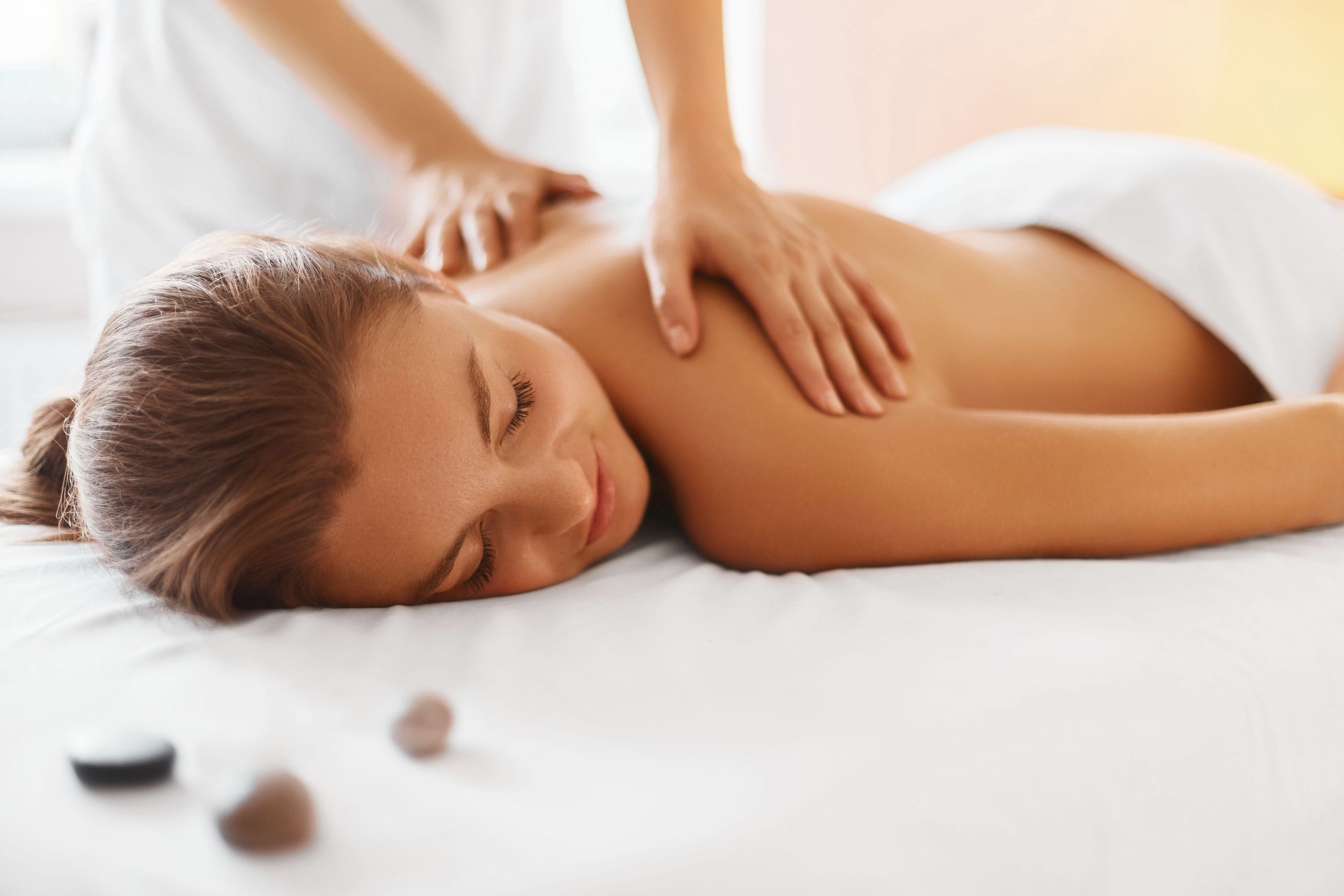 Spa woman. Female enjoying relaxing back massage in cosmetology spa centre. Body care, skin care, wellness, wellbeing, beauty treatment concept.